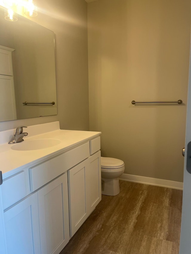 1591 76th St W, Inver Grove Heights, MN 55077 - bathroom with wood finished floors, vanity, toilet, and baseboards