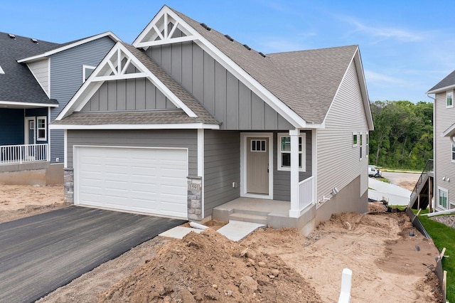 1591 76th St W, Inver Grove Heights, MN 55077 - craftsman-style home featuring board and batten siding, a shingled roof, asphalt driveway, and a garage