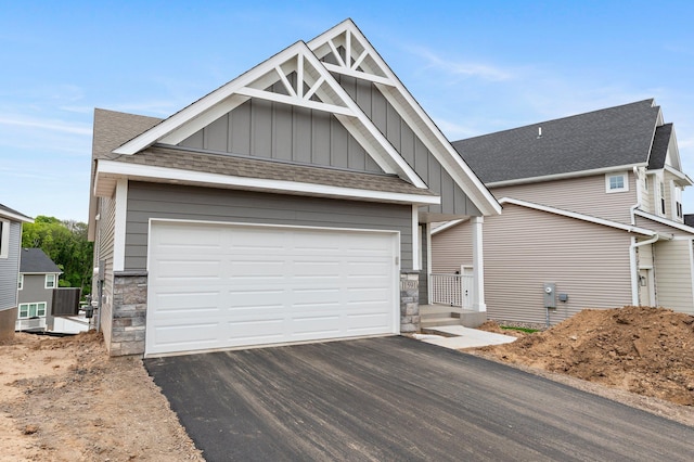 1591 76th St W, Inver Grove Heights, MN 55077 - craftsman-style home featuring board and batten siding, asphalt driveway, stone siding, and roof with shingles