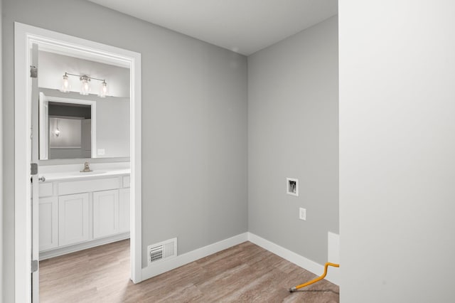 1591 76th St W, Inver Grove Heights, MN 55077 - laundry room featuring light wood-style floors, baseboards, and washer hookup