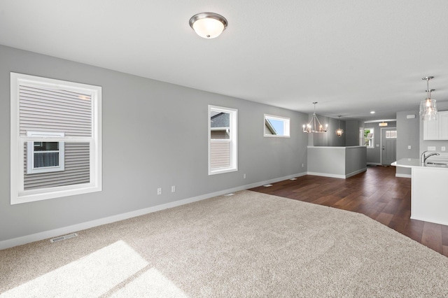 1591 76th St W, Inver Grove Heights, MN 55077 - unfurnished living room featuring dark carpet, a chandelier, and baseboards