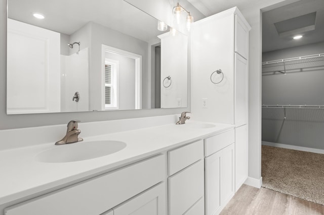1591 76th St W, Inver Grove Heights, MN 55077 - full bath with double vanity, wood finished floors, a walk in closet, and baseboards