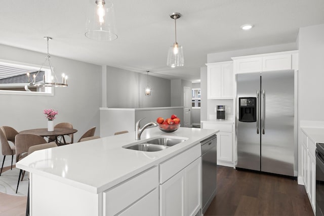 1591 76th St W, Inver Grove Heights, MN 55077 - kitchen featuring appliances with stainless steel finishes, a sink, light countertops, hanging light fixtures, and dark wood-style flooring