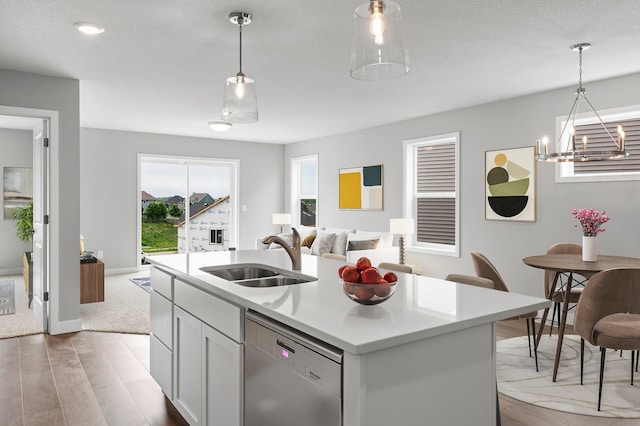 1591 76th St W, Inver Grove Heights, MN 55077 - kitchen featuring dishwashing machine, a sink, light wood finished floors, light countertops, and pendant lighting