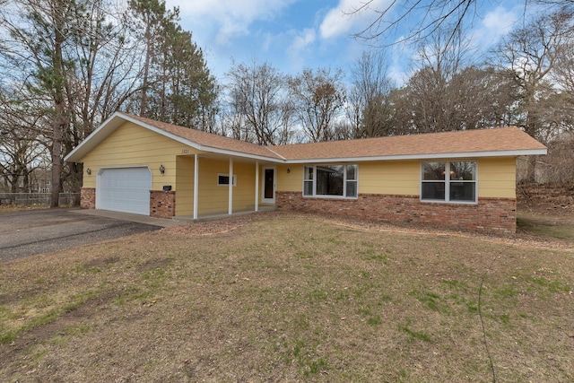 ranch-style home with a garage, driveway, a front lawn, and brick siding