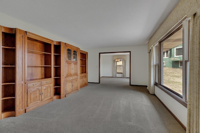 unfurnished living room with carpet floors and baseboards