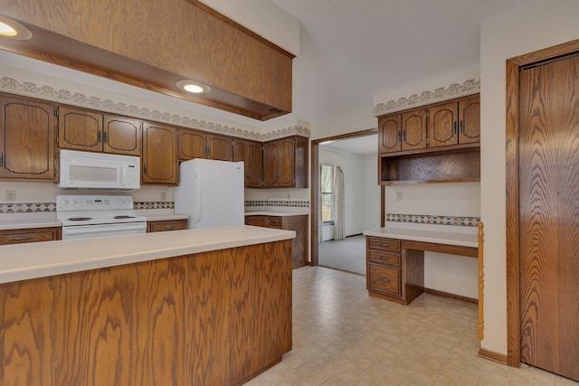 kitchen featuring baseboards, light countertops, light floors, and white appliances