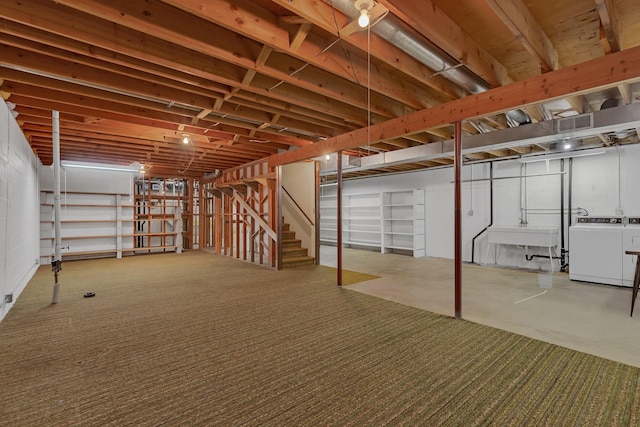basement with a sink, stairway, and washer and dryer