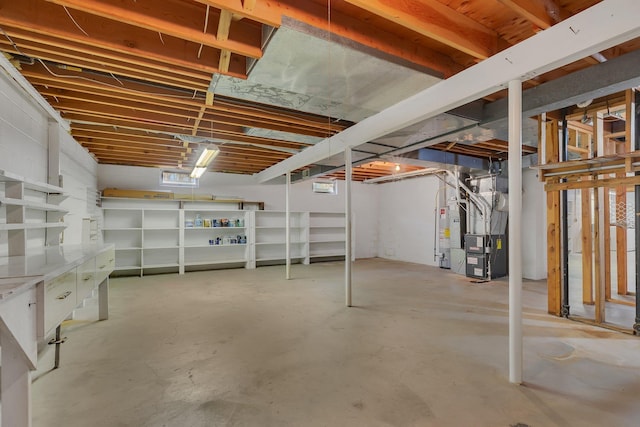 unfinished below grade area featuring heating unit and gas water heater