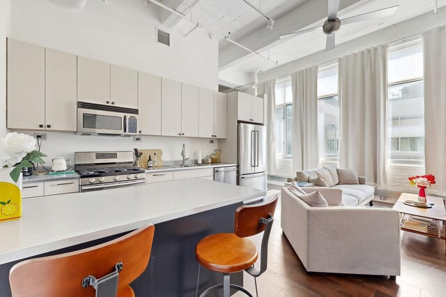 700 Washington Ave N Unit 617, Minneapolis, MN 55401 - kitchen featuring open floor plan, a kitchen breakfast bar, light countertops, rail lighting, and stainless steel appliances
