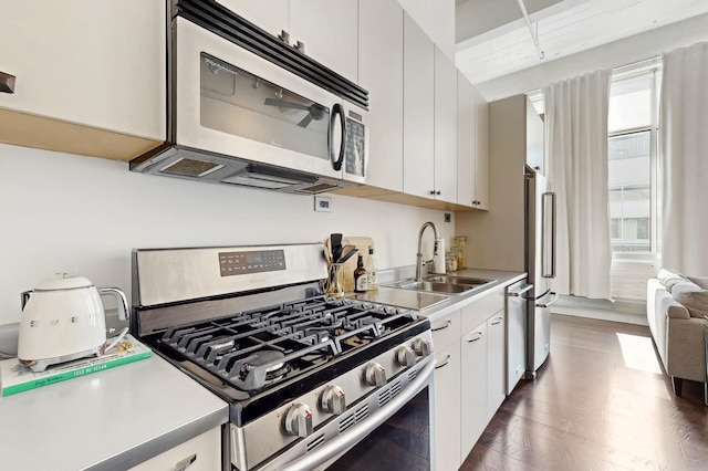 700 Washington Ave N Unit 617, Minneapolis, MN 55401 - kitchen featuring wood finished floors, light countertops, white cabinetry, a sink, and stainless steel appliances