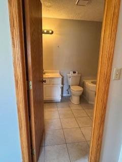 half bath with vanity, toilet, and tile patterned floors