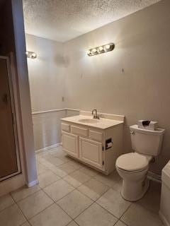 bathroom with toilet, tile patterned floors, a textured ceiling, baseboards, and vanity