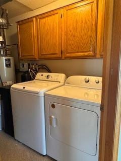 laundry area with cabinet space, washer and clothes dryer, and gas water heater