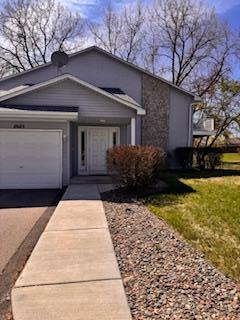 view of front of house featuring driveway, an attached garage, and a front yard