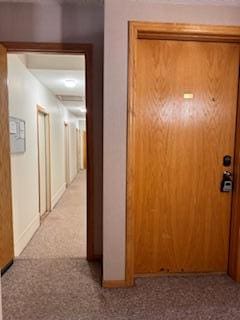 corridor with carpet floors and baseboards