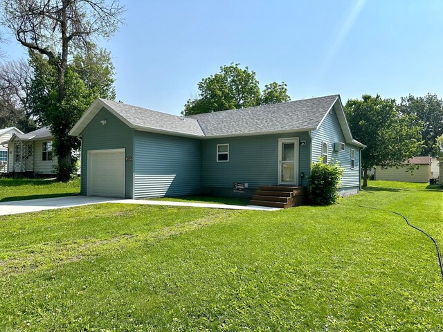 1208 Apel Ave, Worthington, MN 56187 - view of front facade featuring a garage, a front lawn, driveway, and a shingled roof