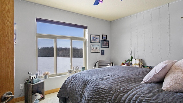bedroom with a ceiling fan, baseboards, multiple windows, and carpet