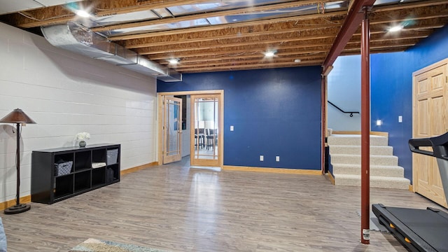 below grade area featuring stairway, baseboards, and wood finished floors