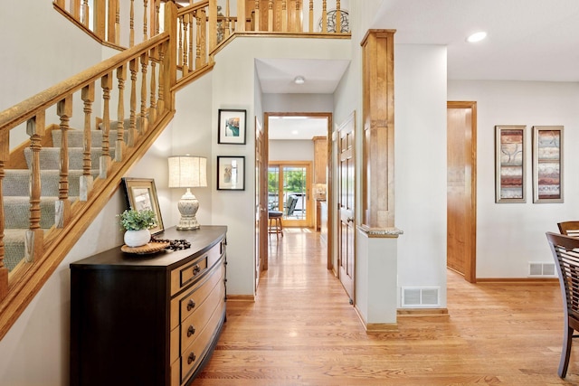 corridor with light wood finished floors, recessed lighting, baseboards, and stairway
