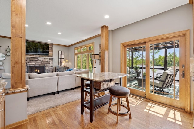 dining area featuring light wood-type flooring, a fireplace, recessed lighting, and crown molding