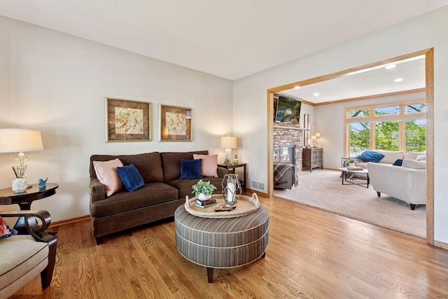 living area featuring baseboards, wood finished floors, a fireplace, and recessed lighting
