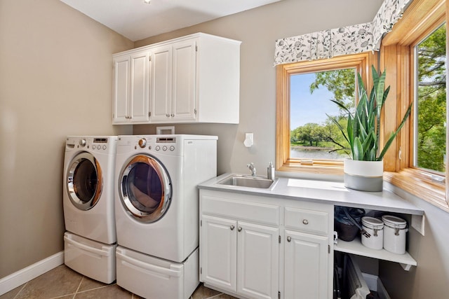 laundry room with cabinet space, washer and clothes dryer, light tile patterned flooring, and baseboards