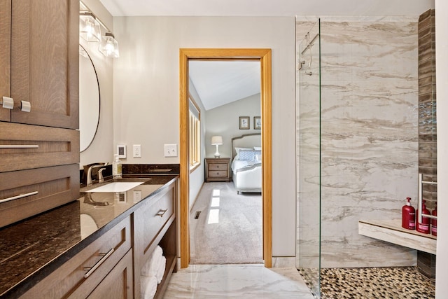 bathroom featuring a marble finish shower, marble finish floors, vanity, and vaulted ceiling