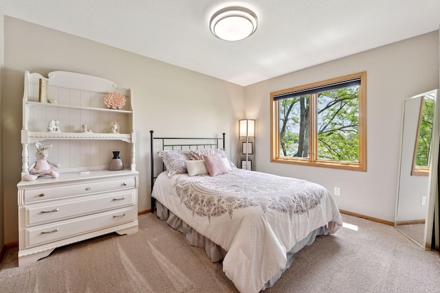bedroom featuring light colored carpet and baseboards