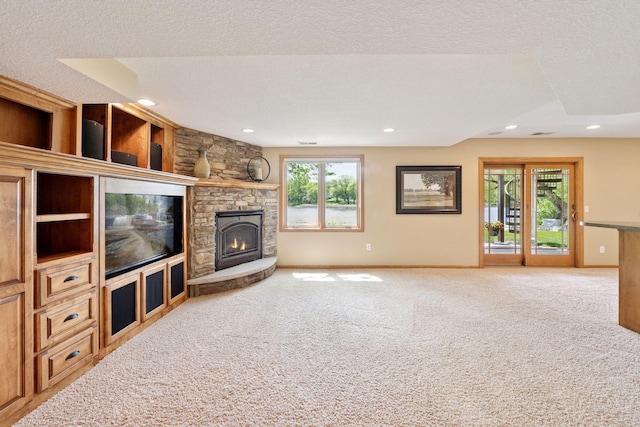 unfurnished living room featuring carpet floors, a fireplace, baseboards, recessed lighting, and a textured ceiling