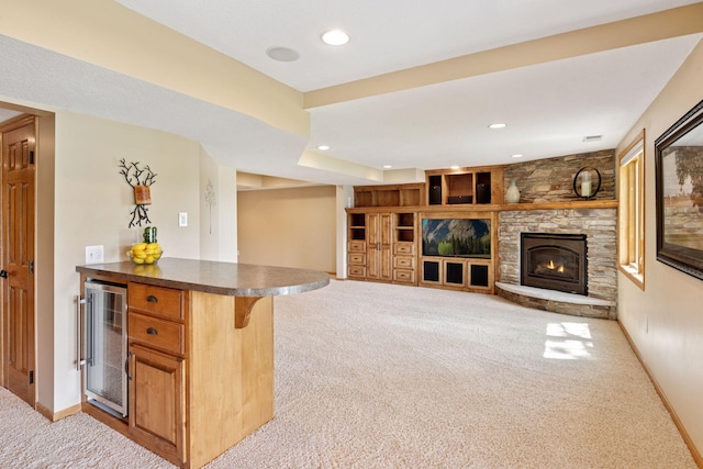 living area featuring wine cooler, light carpet, a fireplace, recessed lighting, and baseboards