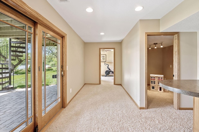 corridor featuring light carpet, baseboards, rail lighting, and recessed lighting