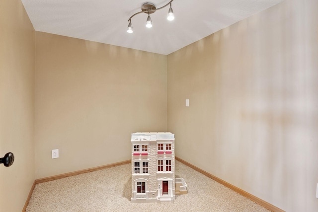 recreation room with carpet and baseboards