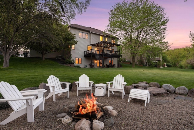 view of green lawn featuring an outdoor fire pit, a wooden deck, and stairway