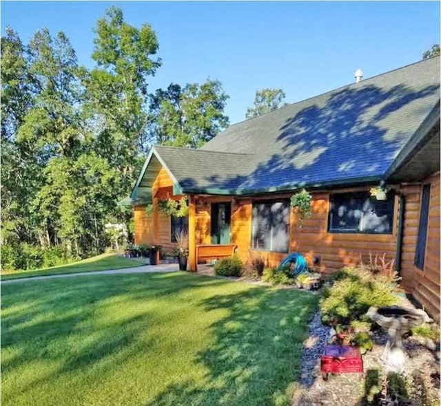 view of front of home with a shingled roof and a front yard