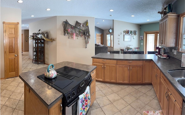 kitchen featuring dark countertops, a peninsula, recessed lighting, and electric range