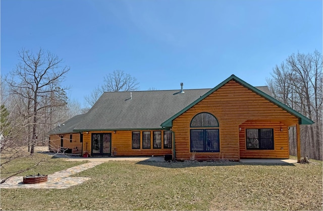 back of house featuring a lawn, faux log siding, and a shingled roof