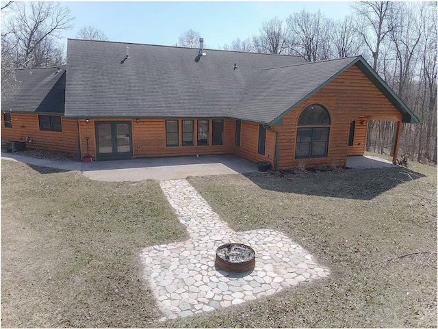 back of property featuring central AC unit, a shingled roof, a patio, and an outdoor fire pit