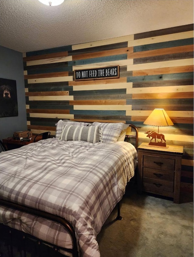 carpeted bedroom featuring wood walls and a textured ceiling