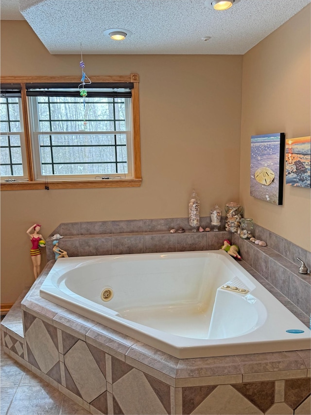 bathroom with a garden tub, tile patterned floors, and a textured ceiling