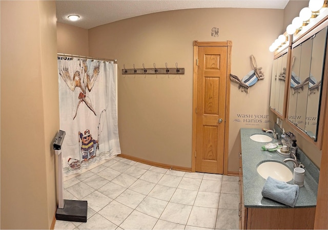 bathroom featuring a shower with curtain, double vanity, tile patterned floors, and a sink