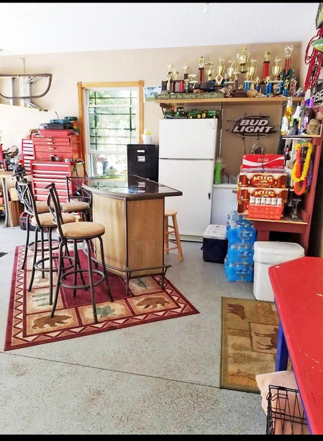 kitchen featuring freestanding refrigerator and speckled floor