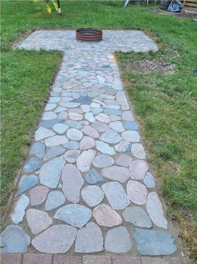 view of property's community featuring a fire pit and a yard