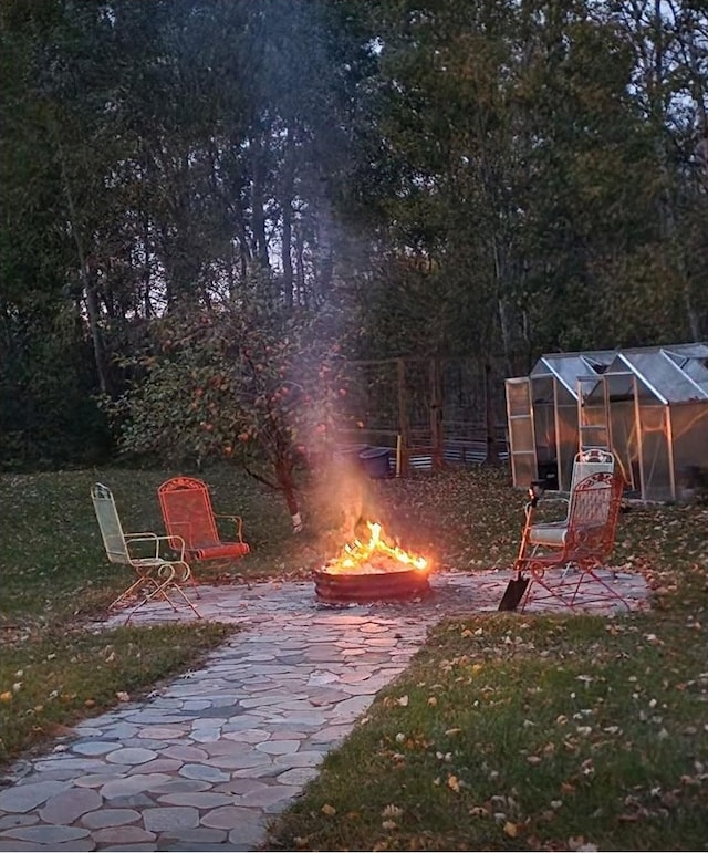 view of yard featuring an outdoor fire pit, an outdoor structure, and an exterior structure