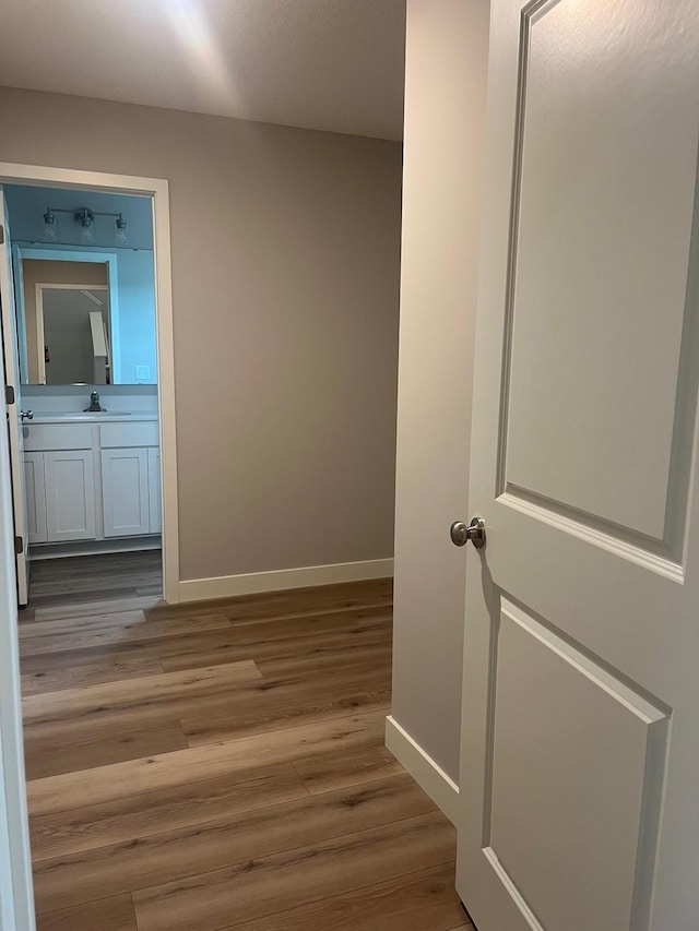 1595 76th St W, Inver Grove Heights, MN 55077 - corridor featuring baseboards, wood finished floors, and a sink