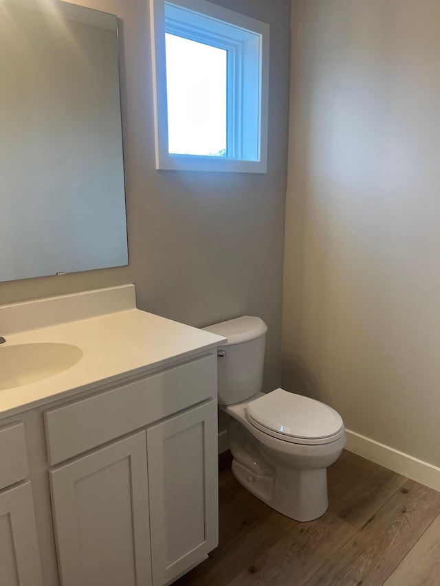 1595 76th St W, Inver Grove Heights, MN 55077 - bathroom with wood finished floors, vanity, toilet, and baseboards