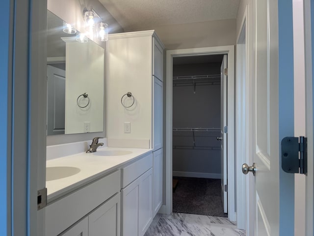 1595 76th St W, Inver Grove Heights, MN 55077 - bathroom featuring double vanity, a walk in closet, marble finish floors, and a textured ceiling