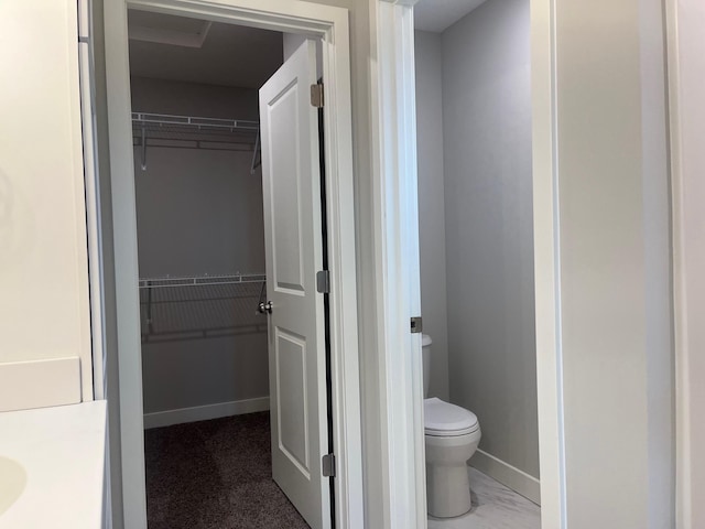 1595 76th St W, Inver Grove Heights, MN 55077 - bathroom with a spacious closet, toilet, baseboards, and vanity