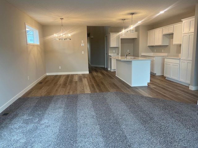 1595 76th St W, Inver Grove Heights, MN 55077 - kitchen with a chandelier, a kitchen island with sink, dark wood-type flooring, and white cabinets