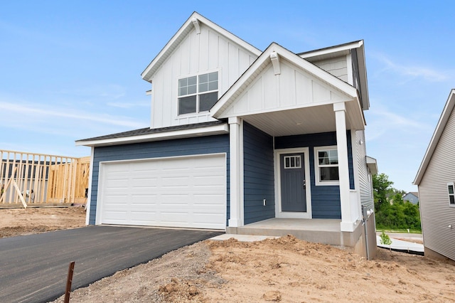 1595 76th St W, Inver Grove Heights, MN 55077 - view of front of home with a garage, board and batten siding, asphalt driveway, and covered porch